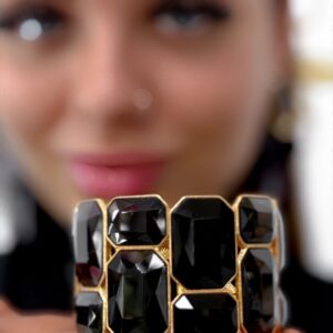 Black and gold colored rubber bracelet decorated with stones of different sizes